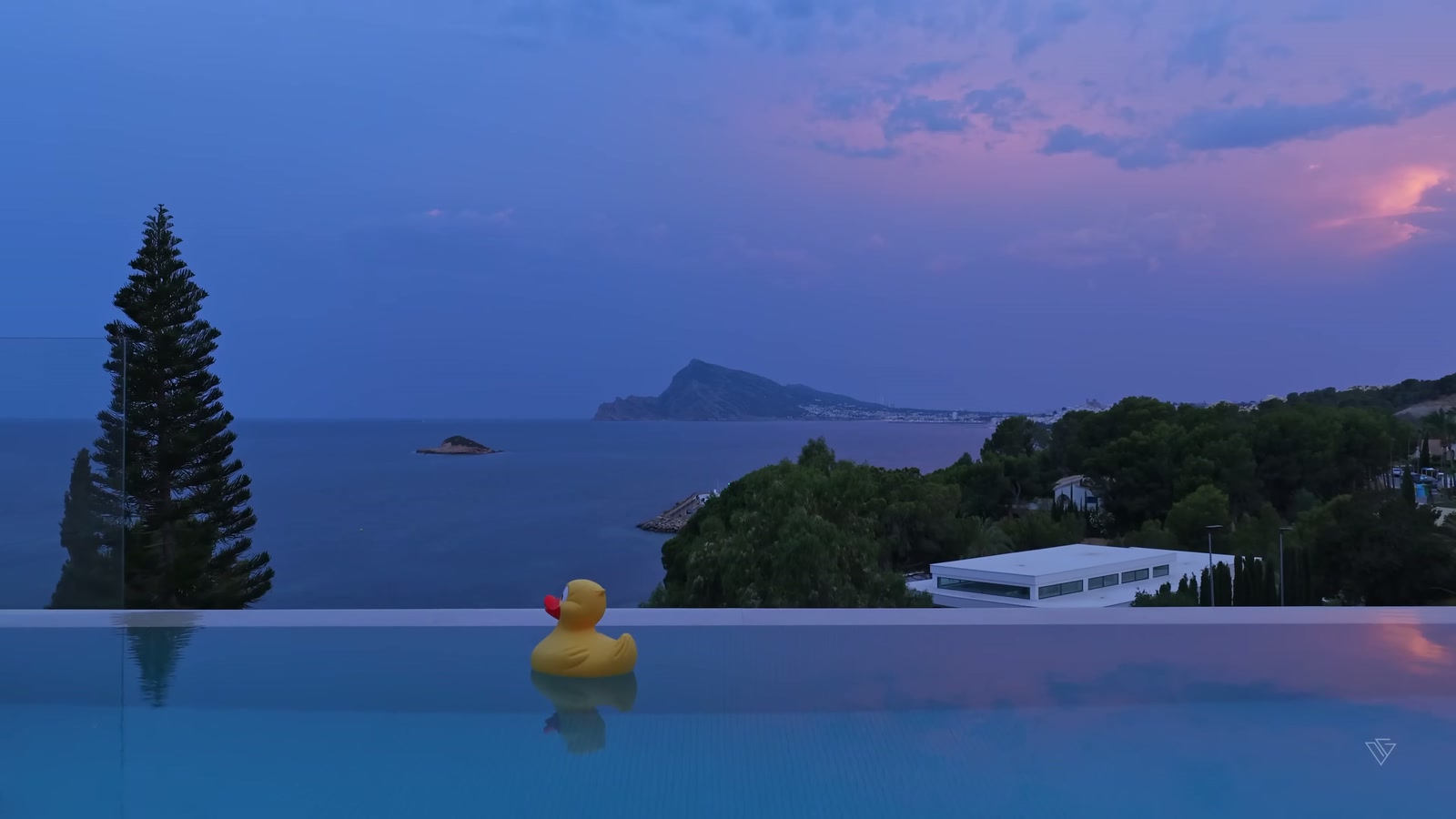 Aerial sunset view of a luxury minimalist villa on a Costa Blanca cliff with infinity pool overlooking the Mediterranean Sea